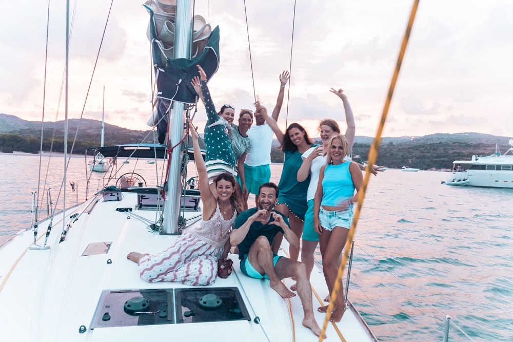 Crew Selfie auf der Yacht im Abendrot vor der Küste Sardiniens in Italien