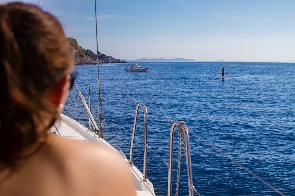 Toller Ausblick von der modernen Yacht auf den Ozean und Stand-Up Paddler