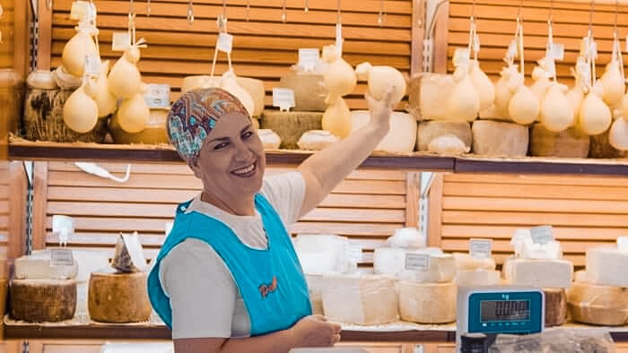 nette Verkäuferin auf italienischen Markt für Käse