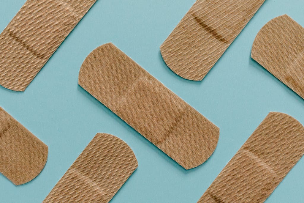A minimalist flat lay of adhesive bandages on a blue background, perfect for health and treatment themes. ann zu Seekrankheit ade führen und deswegen brauch man ein Pflaster gegen Übelkeit